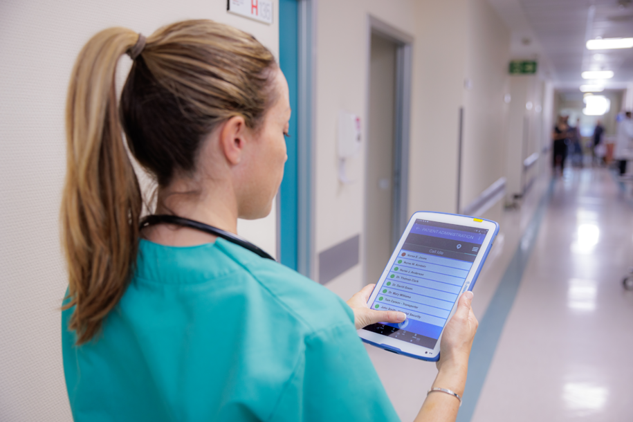 Nurse in a healthcare setting using a Zebra tablet for patient care