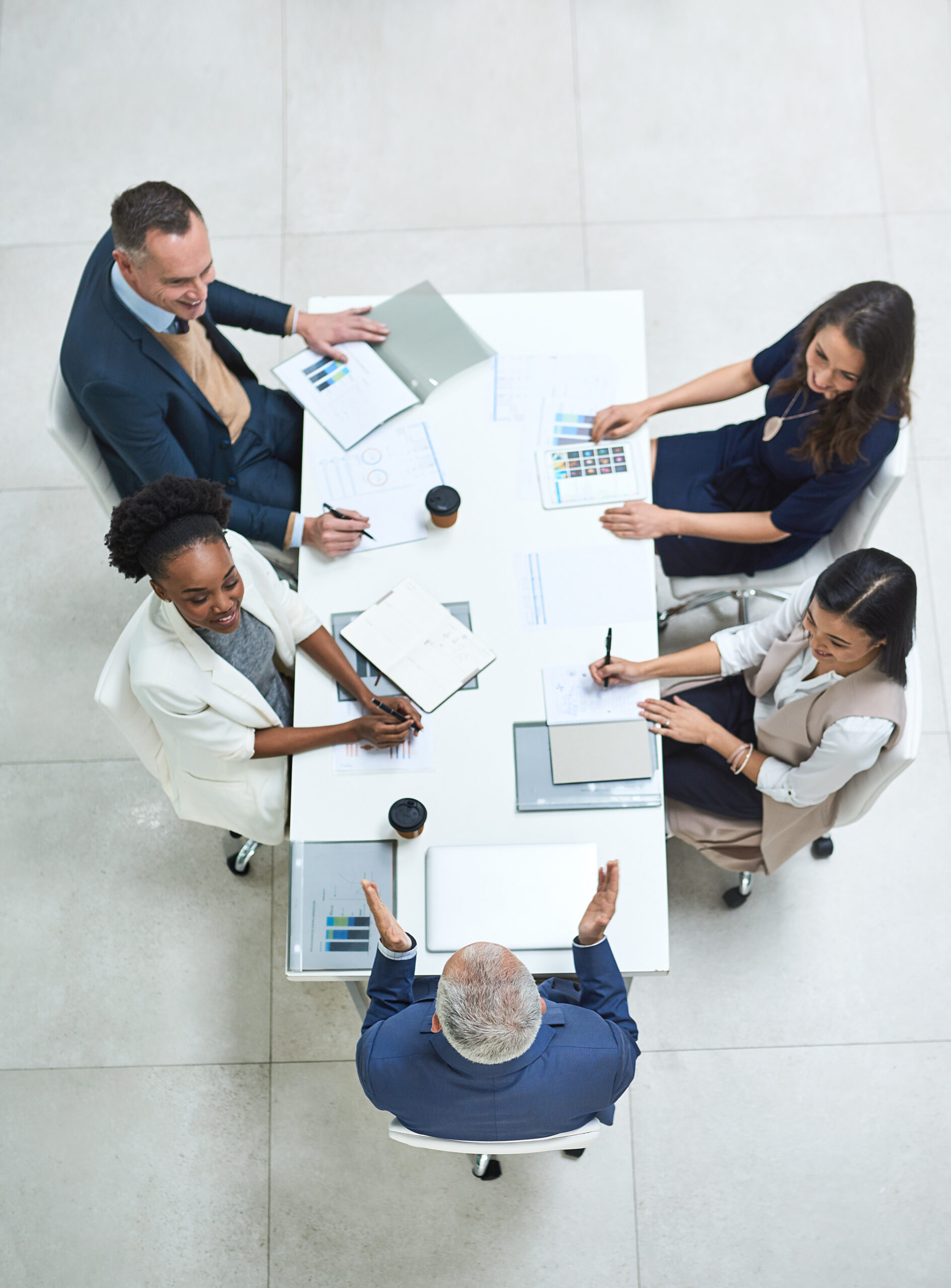 Business professionals in a compliance meeting reviewing data privacy, regulatory frameworks, and cybersecurity standards around a modern conference table